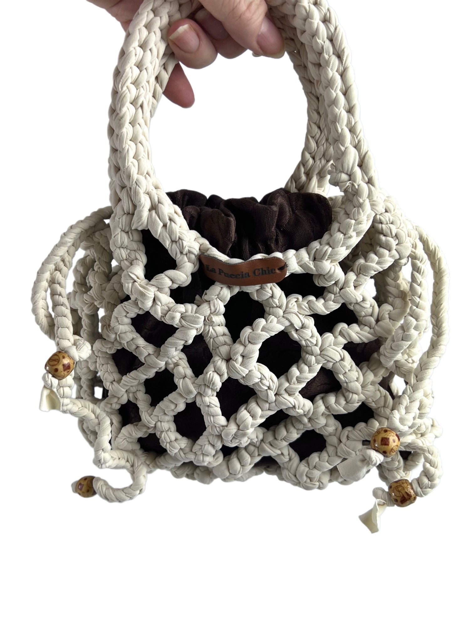 Borsetta interamente lavorata all'uncinetto con il punto puff. Manico catena nera. Inserti neri in fettuccia sfrangiata, nella parte alta della borsa. Foderata internamente.